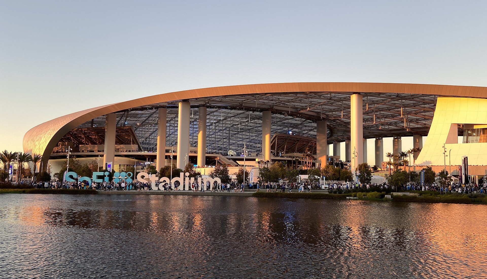 SoFi Stadium at dusk with crowds outside