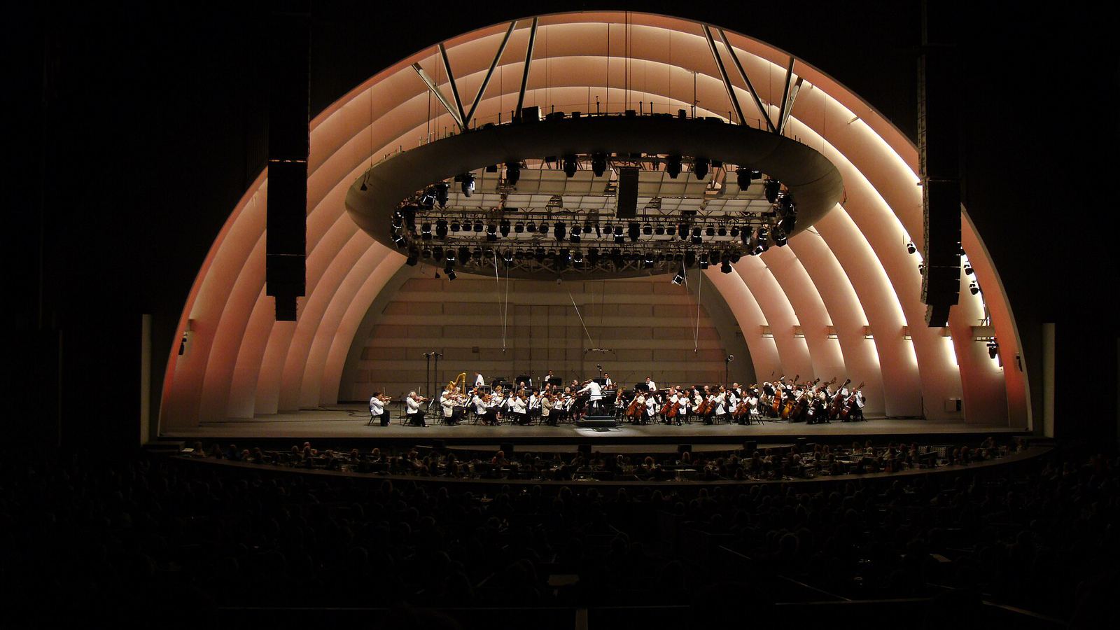 The Hollywood Bowl shell lit at night above a full amphitheatre