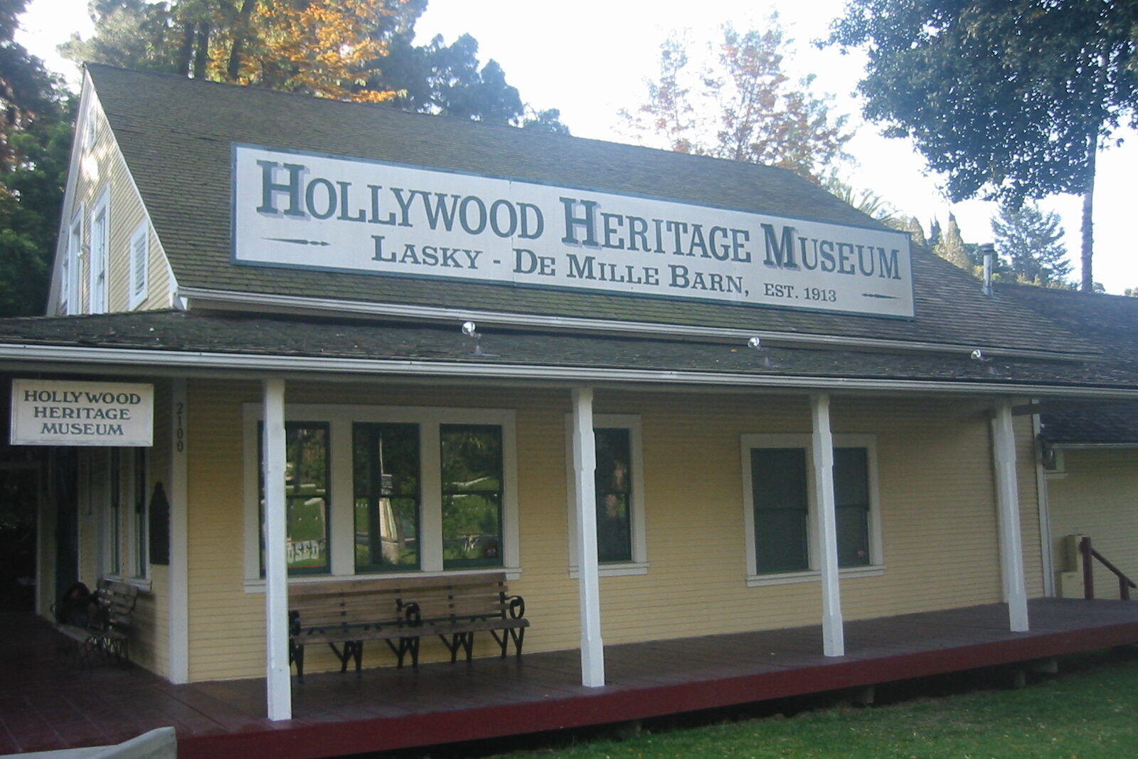 The Lasky-DeMille Barn, a yellow clapboard barn with a long porch, under a sign reading Hollywood Heritage Museum