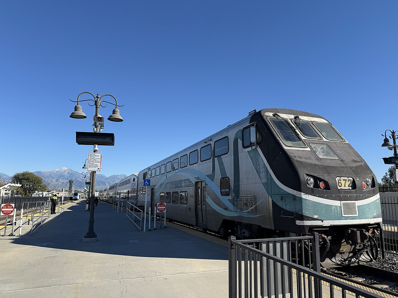 A San Bernardino Line train and an Arrow train standing on either side of the island platform at San Bernardino-Downtown station
