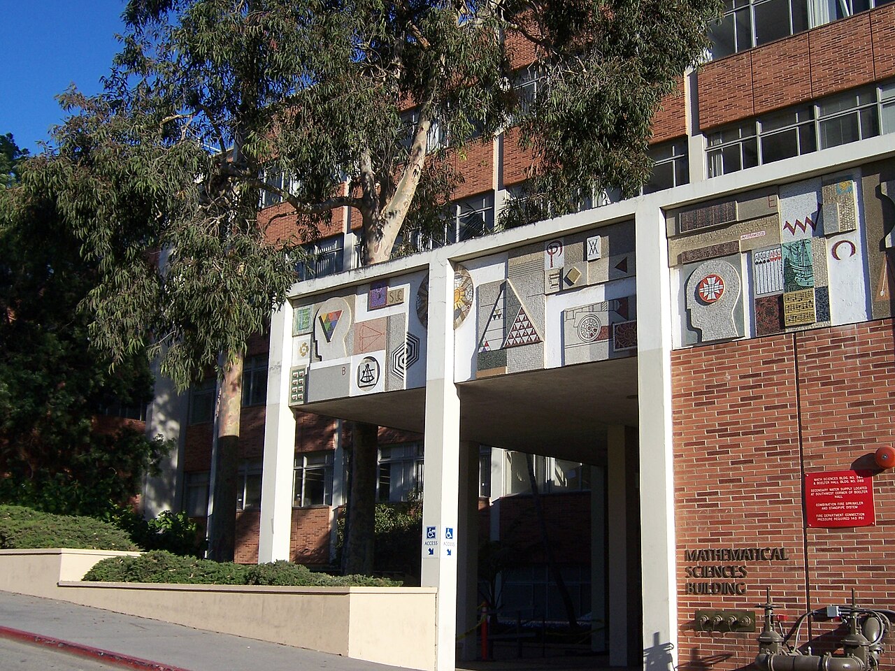 The entrance to UCLA's Mathematical Sciences Building, lettered on brick beneath a row of mosaic panels of geometric figures